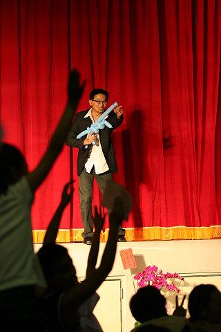 第一名魔-丁民 - 魔術師拿著機關槍找觀眾，觀眾熱情的舉手。