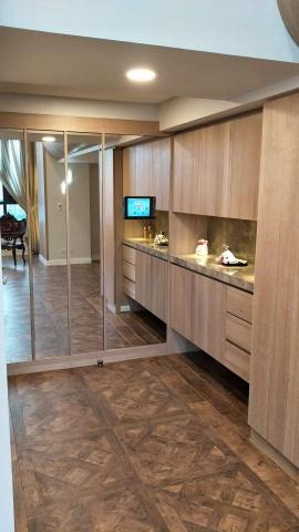 齊威室內裝修工程 - 入口玄關搭配鏡面拉大原本狹小的玄關空間，一進屋入內有寬闊的心情，置鞋櫃、置物櫃與地板相應呈現原木的高雅質感。