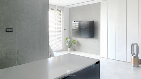 留白設計室內裝修有限公司 - ．Project 000
_在小自宅中釋放更多可能性
從原本的三房兩廳的小房格局轉換為一大房一多功能室，以中島為核心，同為餐廳及工作桌，串聯客廳及多功能房，將原有的走道空間釋放，用透明玻璃區分使用區域，亦可作為白板使用，並放大空間視覺效果，更符合個人工作室需求，讓空間不再被明確定義。
整體利用極簡及低彩度的材質來營造室內質感，提升生活溫度，並提供一個留白、讓居住者用自己的方式填滿生活的空間。