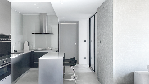 留白設計室內裝修有限公司 - ．Project 000
_在小自宅中釋放更多可能性
從原本的三房兩廳的小房格局轉換為一大房一多功能室，以中島為核心，同為餐廳及工作桌，串聯客廳及多功能房，將原有的走道空間釋放，用透明玻璃區分使用區域，亦可作為白板使用，並放大空間視覺效果，更符合個人工作室需求，讓空間不再被明確定義。
整體利用極簡及低彩度的材質來營造室內質感，提升生活溫度，並提供一個留白、讓居住者用自己的方式填滿生活的空間。