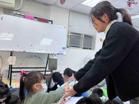 謝佳蓁 - 擔任志工時協助小朋友完成畫作