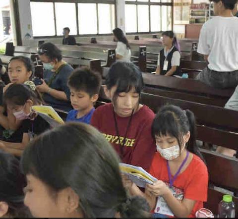 丁亮慈 - 這張照片是在教導小朋友唱營歌 因為有些小朋友還不太會認字