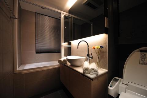 老屋翻新及浴室翻新設計施工團隊 - 浴室採用飯店式燈光氛圍設計，並在有限空間內將淋浴玻璃做到頂設置在浴缸上，關起淋浴拉門時讓浴缸可以變成獨立的蒸汽室。