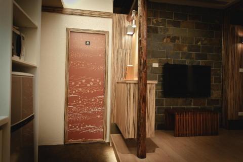 老屋翻新及浴室翻新設計施工團隊 - 這是一道隱藏門，打開後可以先進入到更衣間以及衣物收放間，然後再進入到浴室，並將石材帶到客廳牆面讓全式有一致的氛圍。
