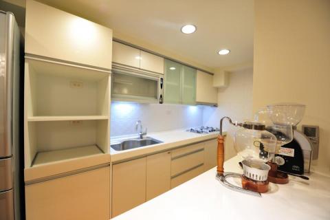 老屋翻新及浴室翻新設計施工團隊 - 廚房有防水耐髒的板材設計，也有寬敞的空間讓女主人可以大顯身手。並配置電器櫃與專用迴路，抽拉式設計可放置飯鍋，上層可以放置微波爐/烤箱/等高電流廚房電器。