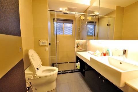 老屋翻新及浴室翻新設計施工團隊 - 使用乾溼分離的設計，設置遙控型免治馬桶，並在檯面增設大空間可以擺放浴室昱品，鏡櫃以及下方置物櫃也可以放置備品。廁所門使用隱藏門設計，跟牆壁結合為一體，看不出廁所門。