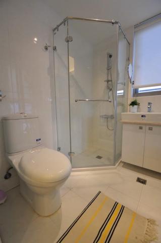 老屋翻新及浴室翻新設計施工團隊 - 套房式淋浴間，採用白色系建材以及設備來增加明亮乾淨的感覺。並在角落空間設置多角形淋浴間。