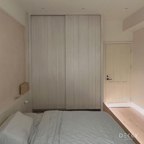 黛瓅設計 - 雅緻女兒房 |
融合木質元素與潔白牆面，我們為您的女兒打造了一個優雅而溫馨的空間。特別設計的床背牆，結合了藝術塗料與實木貼皮，不僅美觀，更節省了床頭空間，為房間增添了更多活動空間。床背板巧妙地設計成多功能收納空間，方便放置手機、書籍等小物品。床邊的插座與電燈開關考量到了使用者的便利性。

考慮到屋主女兒已是一位擁有小孩的母親，我們特別選用了架高的和式地板代替傳統床架，為小孩提供更安全的睡眠環境。