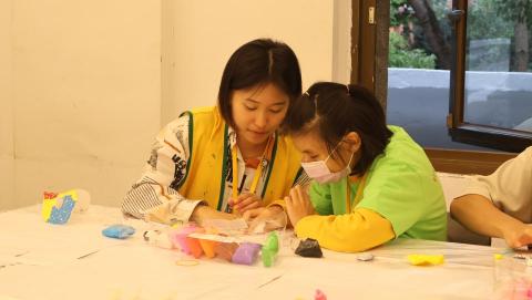 音樂家教/藝術啟蒙 - 為亞斯伯格症設計的藝術營隊裡，擔任課程設計與教學。圖為陪伴自閉症者一步一步完成手作體驗，也藉此訓練他們的手部小肌肉。