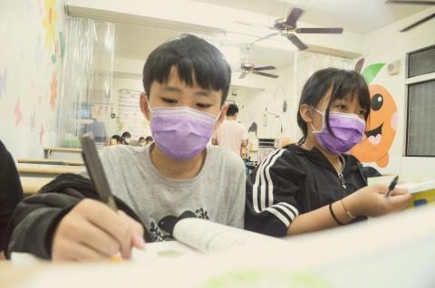 王振崎 - 在台中市文化協進會輔導孩子國小數學，圖為兩個孩子學習的樣子。