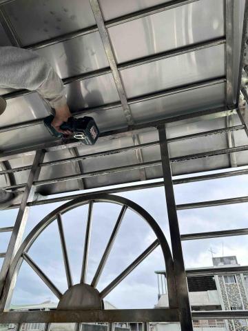 專業鐵工「效率、品質、價格合理」 - 不銹鋼板遮雨棚。不易損壞、不怕掉落物，使用年限極長，但夏天比較熱且不透光。