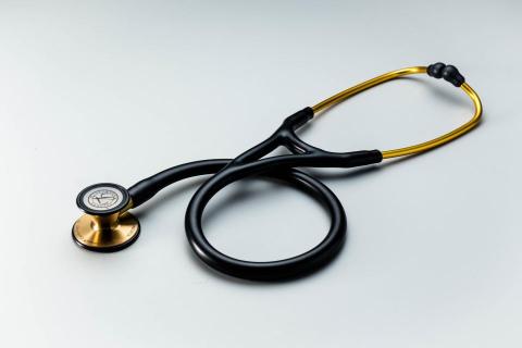 黃俊 - 1.拍攝方式：使用專業燈光拍攝，透過精準光影凸顯聽診器的金屬質感與流線型設計，展現醫療器材的專業與高端。
2.背景設計：選用極簡淺灰色背景，讓產品在畫面中更具焦點，同時營造出潔淨且專業的醫療氛圍。
3.色彩呈現：黑色與金色的經典搭配，強化視覺對比，提升產品的質感與辨識度。
4.作品特色：本作品結合極簡風格與高質感燈光效果，清晰呈現產品細節，特別適合用於醫療設備型錄、品牌宣傳、網路商城展示等商業用途