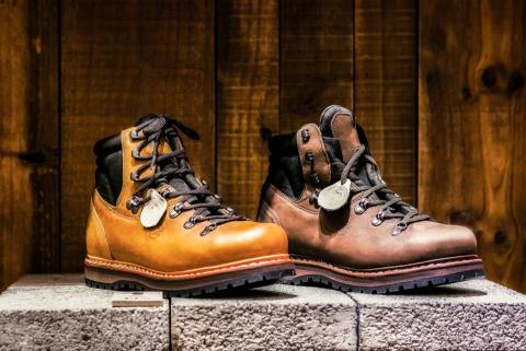 黃俊 - 拍攝方式：

專業燈光拍攝，突出皮革質地與縫線細節
呈現鞋款的堅固耐用與高端質感
背景設計：

木質背景結合水泥展示台，營造戶外與自然氛圍
提升產品與場景的一致性，凸顯品牌形象
色彩呈現：

強調皮革的自然色澤與光澤
暖色調背景搭配深色鞋底，增強對比效果
作品特色：

展現登山靴的耐用性與機能性
細節清晰可見，如鞋帶、鉚釘及鞋底紋路
適用範疇：

戶外裝備型錄
品牌行銷宣傳照
電子商務平台產品展示