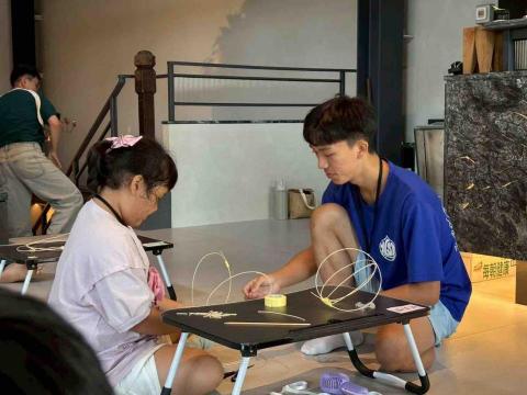 江育廣 - 參與自閉症藝術體驗營志工，帶領學生完成竹製藝術品