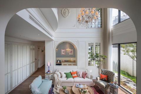 Melody Interior Design - 我們保留了原本珍貴的挑高優勢，運用經典的**「法式圓拱」線條**修飾生硬樑柱，讓視覺無限延伸。大面落地窗搭配實木百葉，將戶外綠意與自然光引入室內，與璀璨的水晶吊燈相互輝映。

木紋磁磚搭配我們精心挑選的跳色抱枕與復古家具，讓氣派的空間不失家的溫度。如果您也嚮往這種經典、不退流行的居家風景，歡迎與我們聊聊。

#鄉村風 #法式風格 #挑高設計 #老屋翻新 #軟裝設計