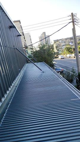 憬鴻鋼鐵設計工程行 - 本案雨棚採用長城鋁板搭建，板型立體俐落，整體外觀質感大幅提升。鋁板具備優異耐候與抗腐蝕特性，不易生鏽，使用年限長，能有效降低後續維護成本。結構輕量卻兼具高強度，對原有結構負擔小，施工快速穩定。板面銜接緊密，排水順暢，可有效減少滲漏與積水問題，同時兼具遮陽、防雨與美觀效果，適合住宅、店面及各類空間加裝使用。