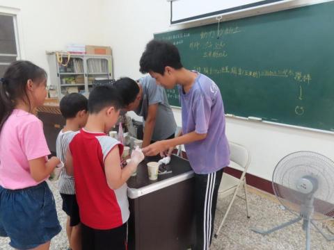 朱鈺雄 - 在志工服務處帶國小學生簡易科學實驗(圖中紫色衣服為本人)
