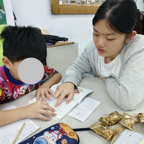 陳琪惠 - 在 2025 年暑假，我於「優力卡社區服務協會」擔任課輔助理。該單位致力於減輕弱勢家庭的經濟與教養負擔，並與家長、學校聯合，共同肩負起兒童及青少年教養的責任。
此圖是陪孩子進行故事書陪讀。在與孩子們共讀故事、互動的過程中，我被他們的純真與活力深深觸動。我深信，良好的教育能「反轉弱勢，創造優勢」。這份對教育的熱情，我希望能帶入未來的家教教學中，陪伴的孩子在充滿支持的環境下成長。